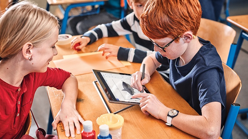 Zwei Schulkinder bei der Arbeite an einem Laptop