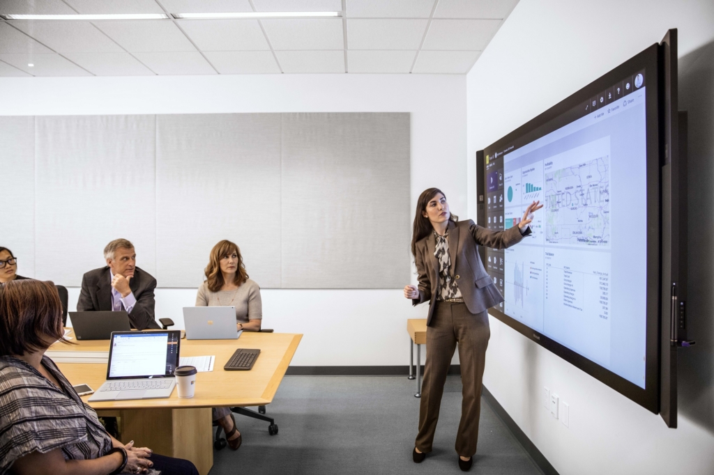 Eine Geschäftsfrau im Business-Look präsentiert in einem Konferenzsaal. Eine Geschäftsfrau im Business-Look präsentiert in einem Konferenzsaal über HPC.