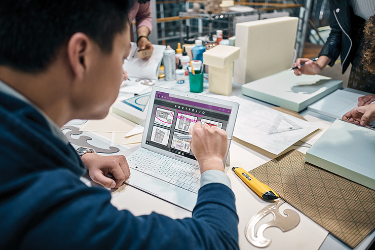 a group of people looking at a laptop