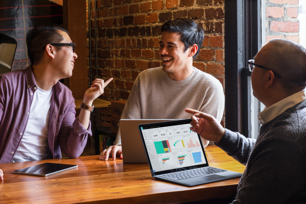 Customer experience team meeting at large table smiling in discussion