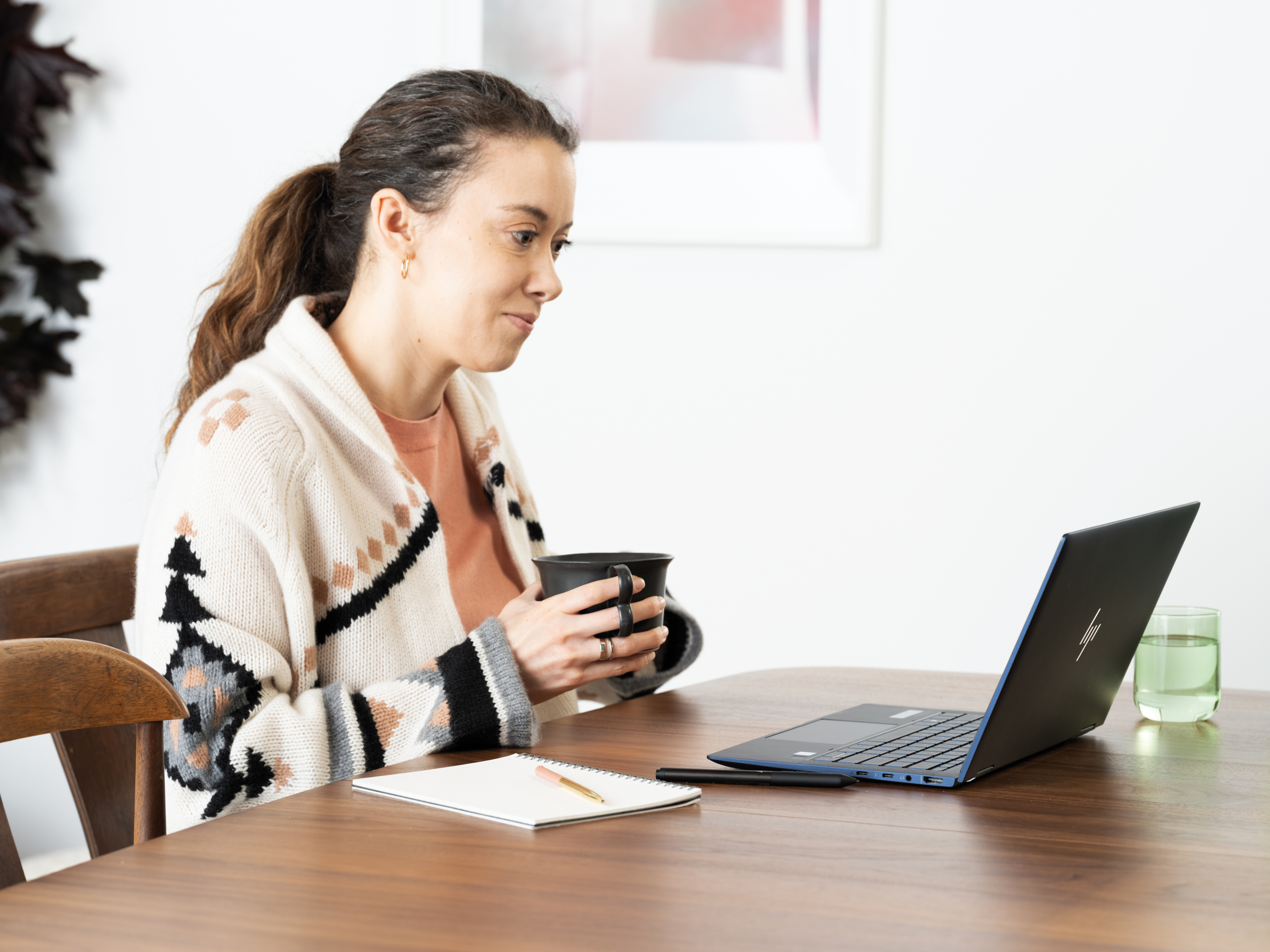 a woman sitting at a table using a laptop computer