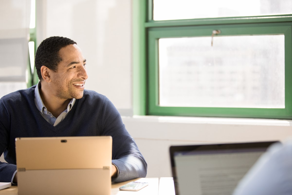 Small business male with laptop achieving in modern workplace