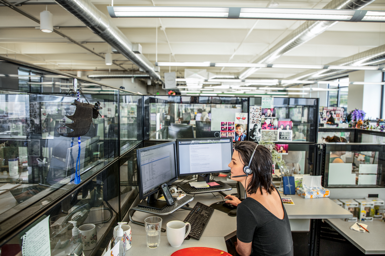 Photo of a female call center employee working at a cubicle desk