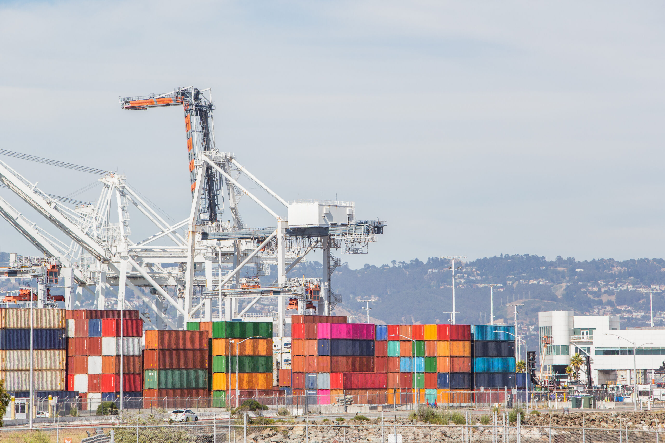 Photo of shipping port featuring cranes and stacks of containers