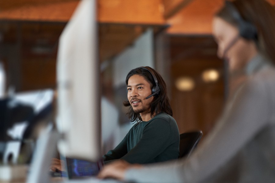 Man sitting at a computer with a headset on