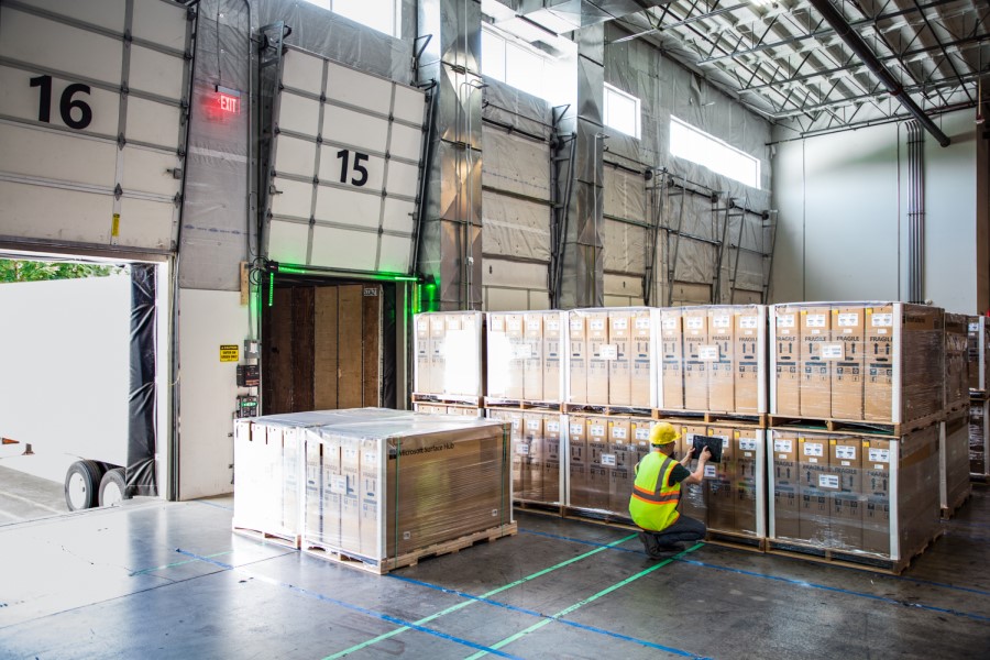 Person scanning pallets in a warehouse