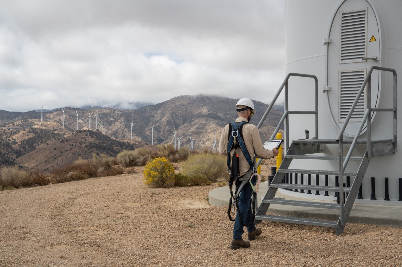 Field engineer viewing data after the inspection of turbines on a wind farm
