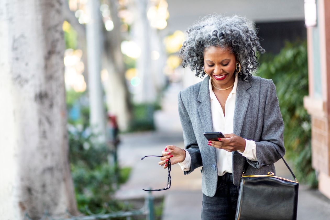 A business leader texting while walking in a city