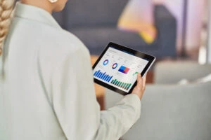 Retail store manager walking the store floor and analyzing data on a tablet.