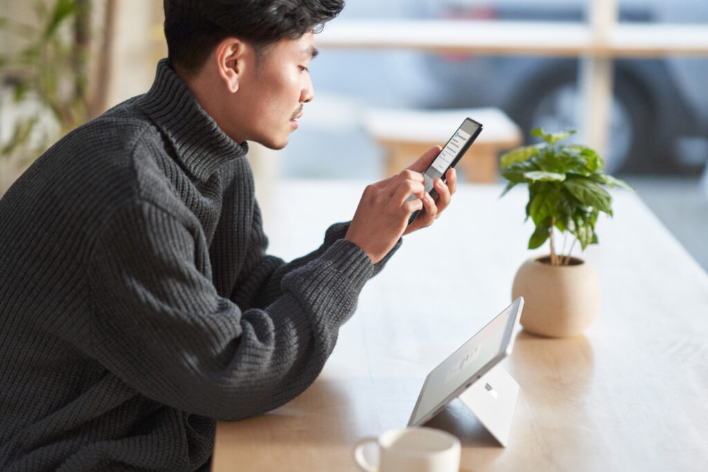 User securely using multi-factor authentication on a mobile phone and a tablet while working remote from a café.