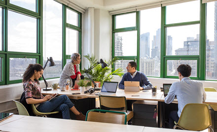 A team sits around a table in an office for a meeting