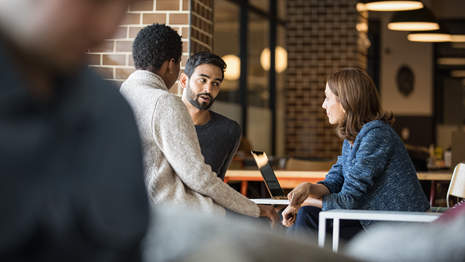 A meeting between several workers takes place in a cafeteria