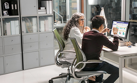 Image of two firstline workers collaborating at a desk in an office space