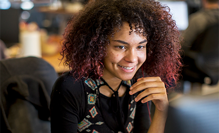 Image of a worker smiling at her computer