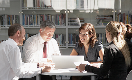 Image of five Korn Ferry employees meeting around a desk