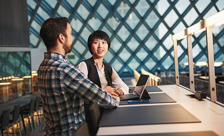 Image of two employees collaborating over a laptop