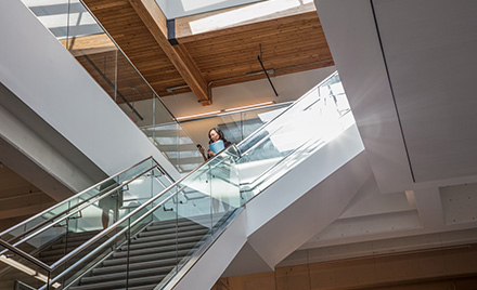 Image of a worker descending a staircase while looking at her phone