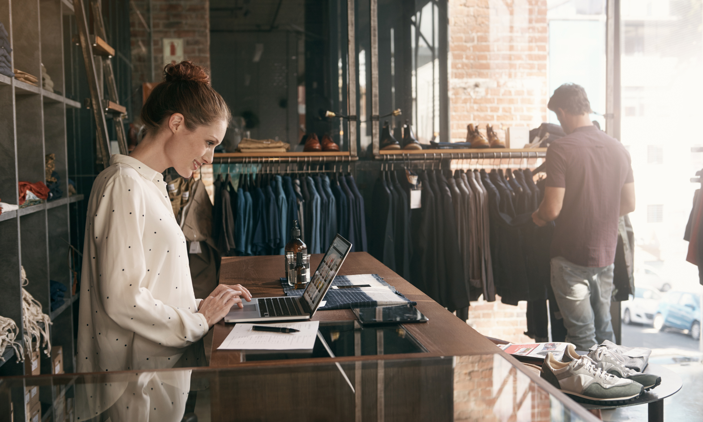 Store owner using device at register counter