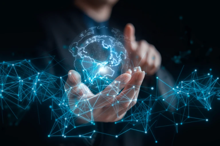A person holding a digital hologram of a globe with interconnected blue lines