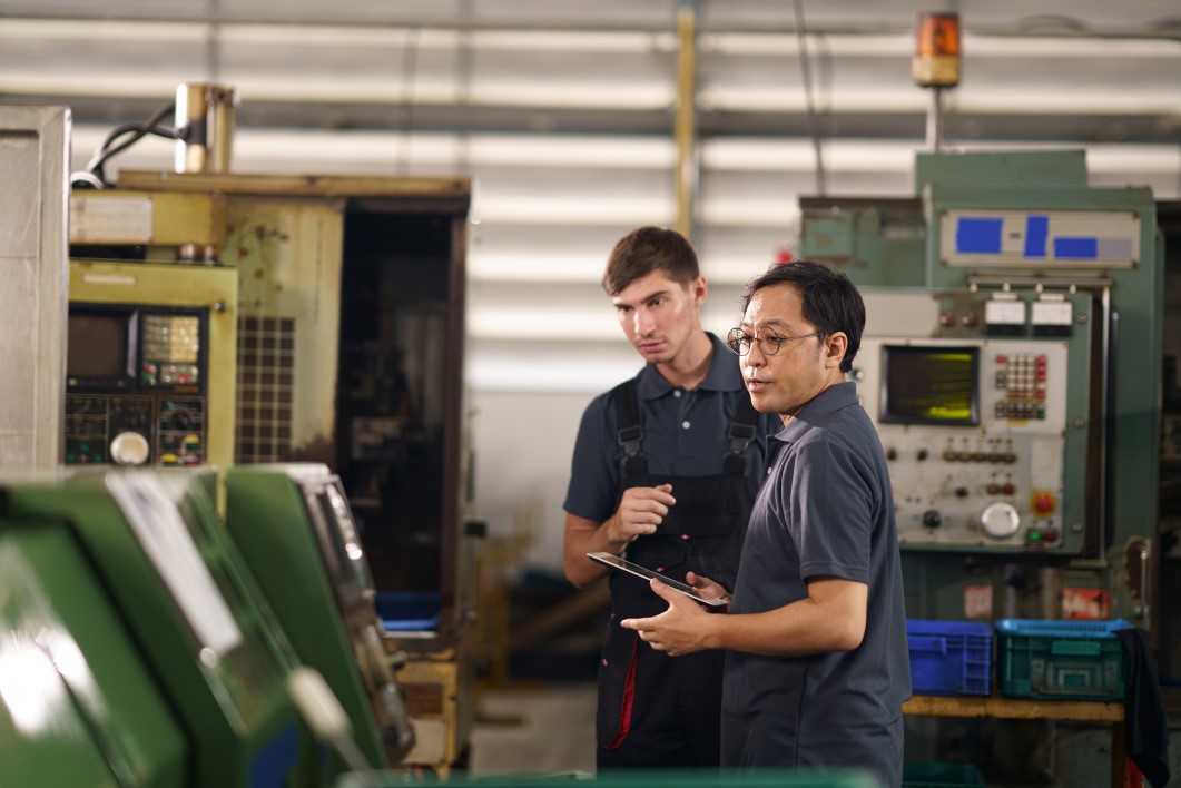 Technicians inspect CNC machines using computer controlled software programs