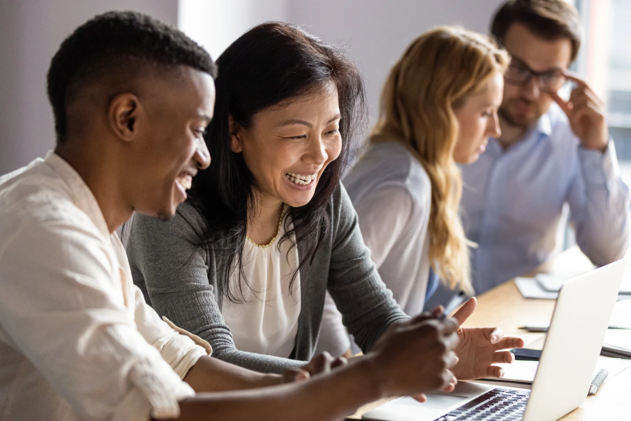Happy mature businesswoman discussing a project on laptop with a young colleague