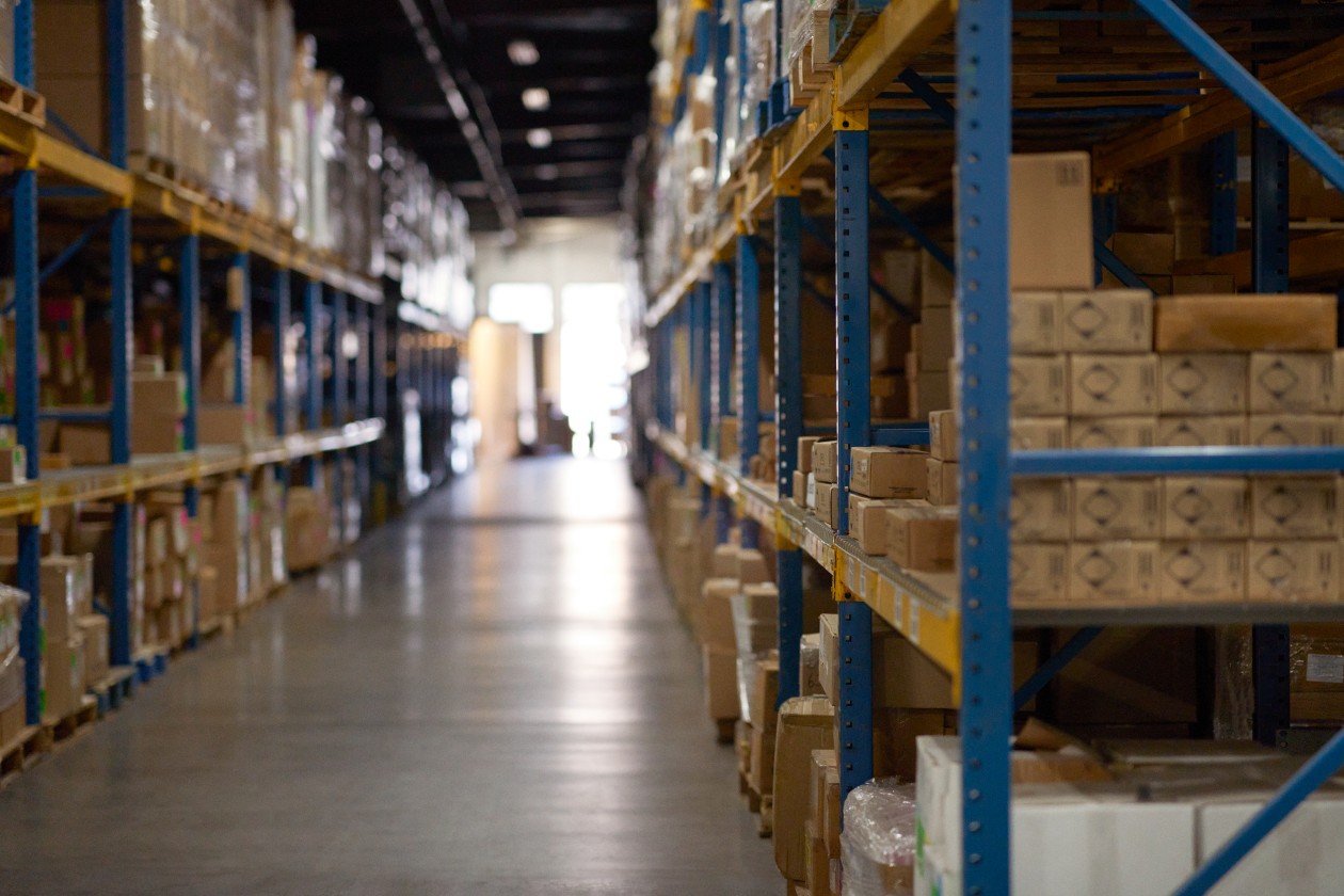 Cinematic wide shot of warehouse with silhouette of worker in background