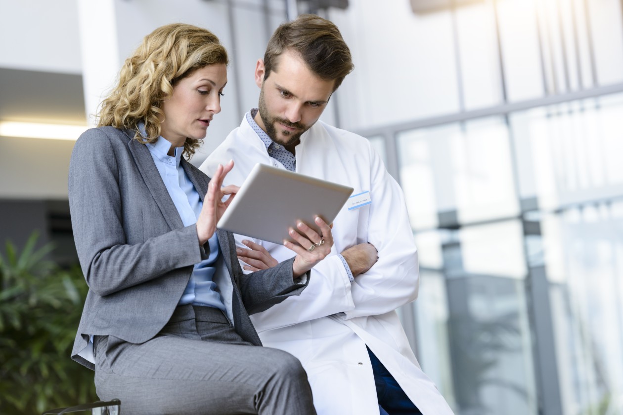 A man and woman looking at a tablet