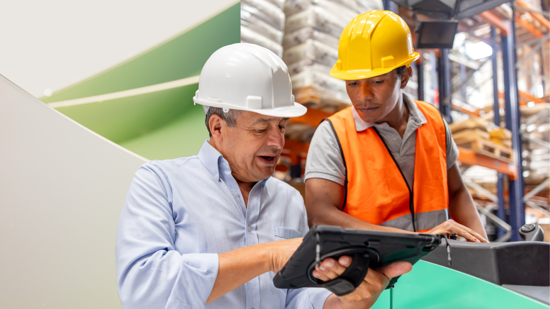 Two manufacturing professionals look over a tablet while on the job site