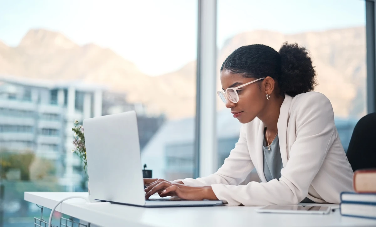 Shot of a young businesswoman using a laptop at her desk in a modern office