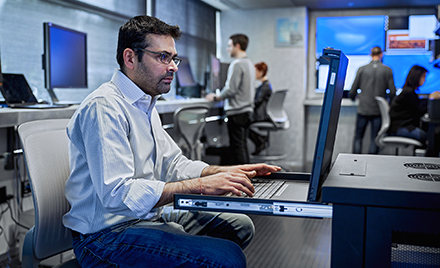An image of a tech worker on his laptop PC