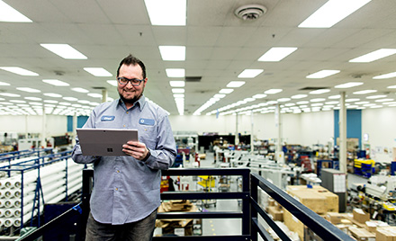 Image of a worker in a warehouse looking at a tablet