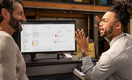 Image of two men in front of a computer monitor