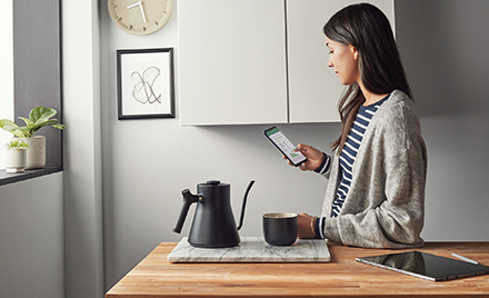 Image of a worker in a kitchen looking at her phone