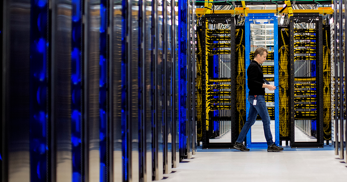 Image of a worker walking through a datacenter