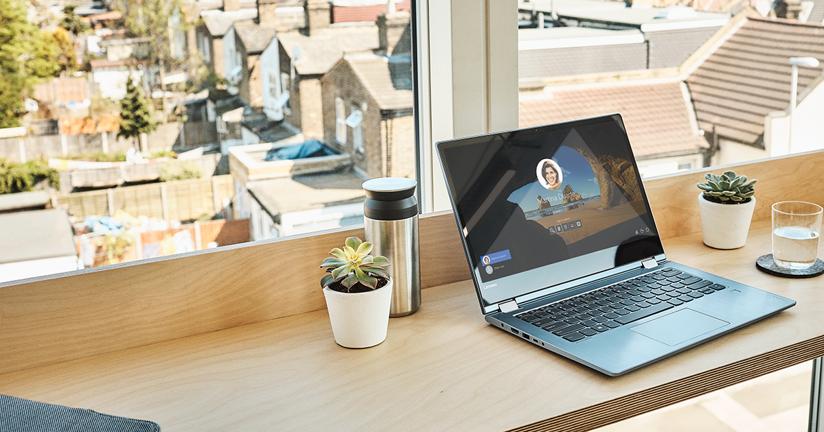 Image of a laptop open on a countertop, a cityscape in the distance