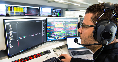 An image of a technician examines performance test results in racing stimulator of Formula One manufacturing plant