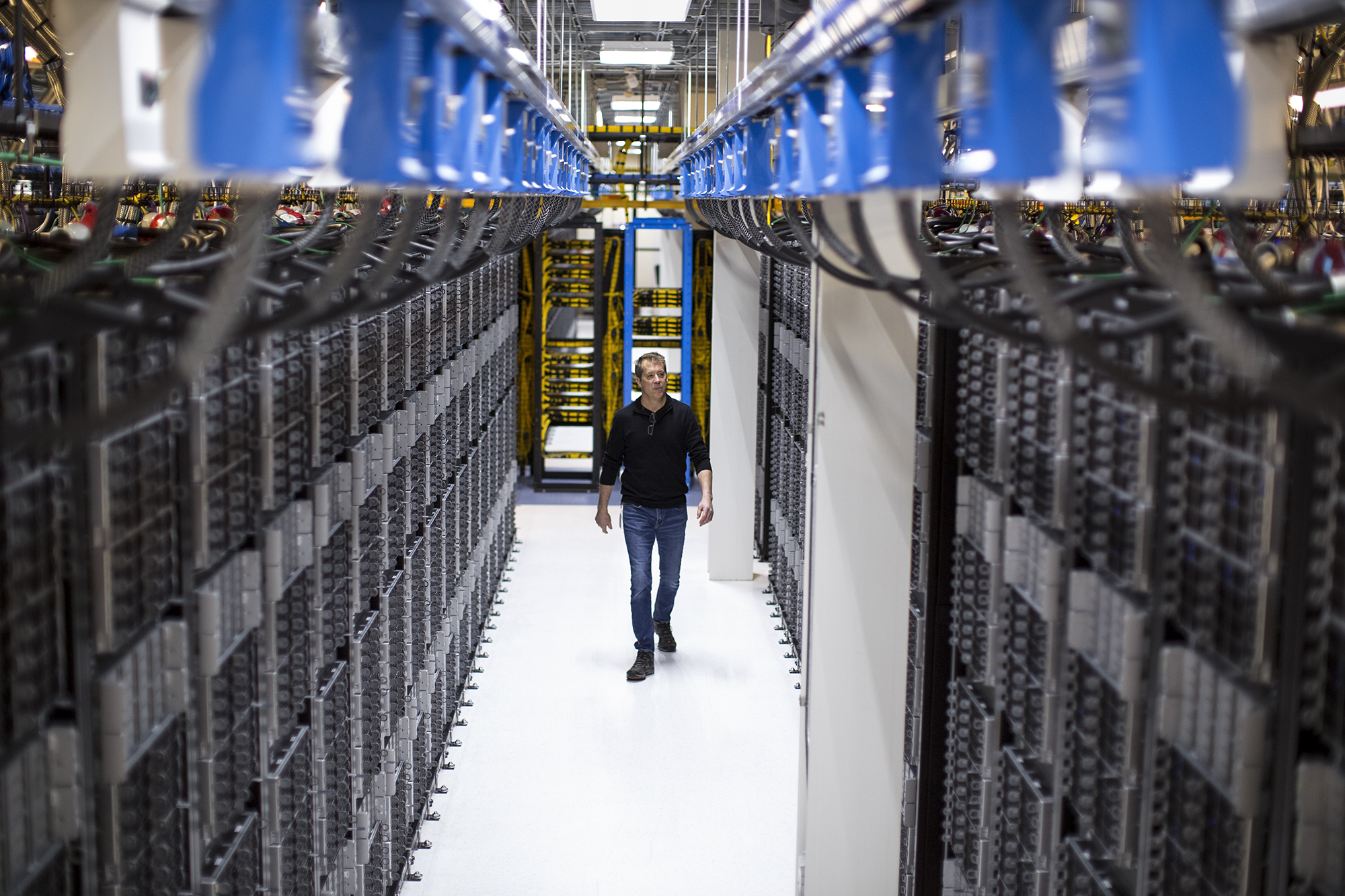 image of a man walking through a State-of-the-art facility uses eco-friendly solutions such as using reclaimed water to cool the data center