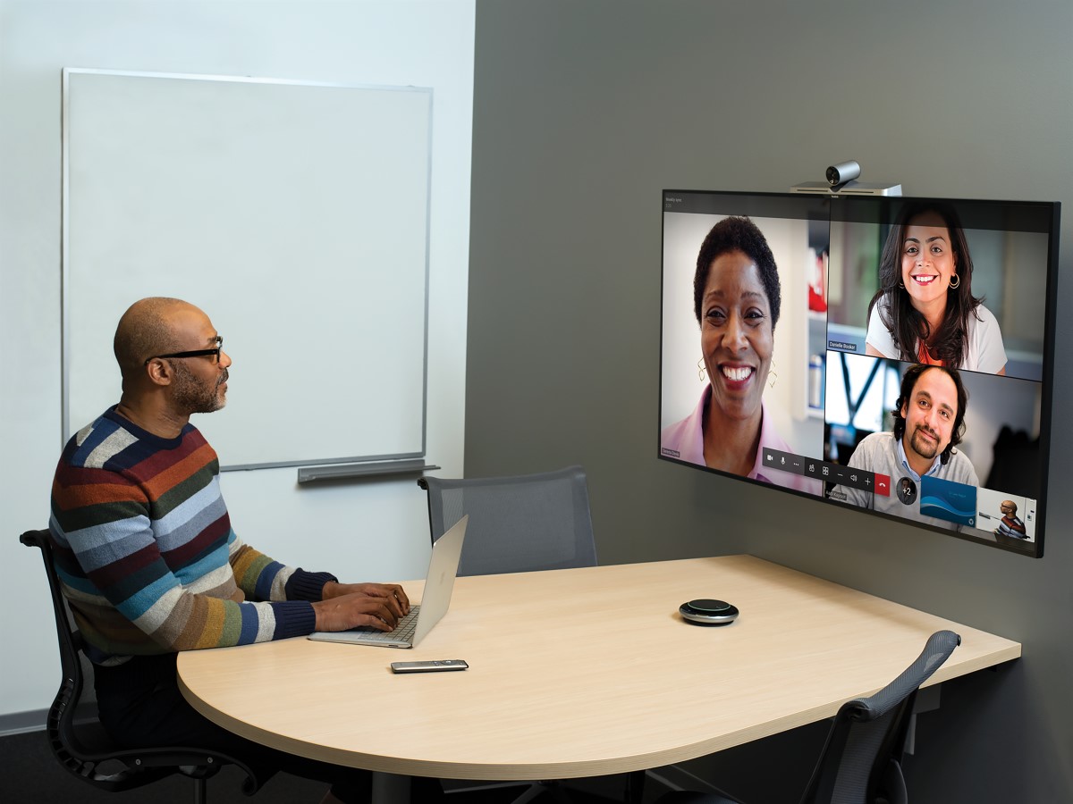 One male in small conference room being used for remote video meeting with Teams Meetings