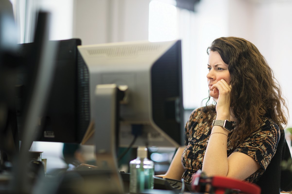 Adult woman sitting behind a computer screen