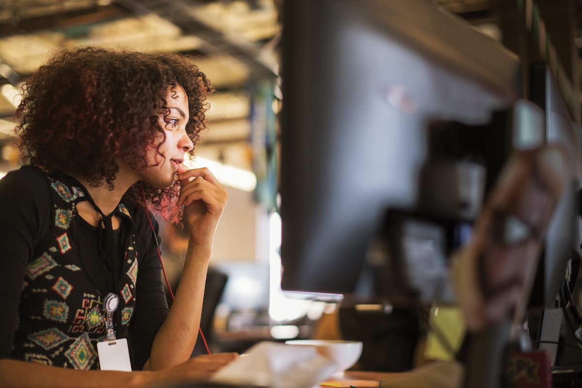 Adult female IT professional working at her computer station