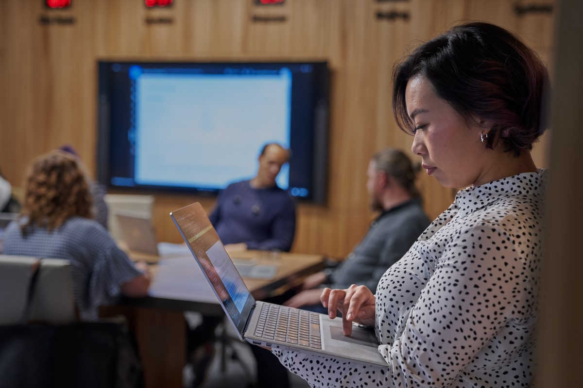 woman standing looking at laptop