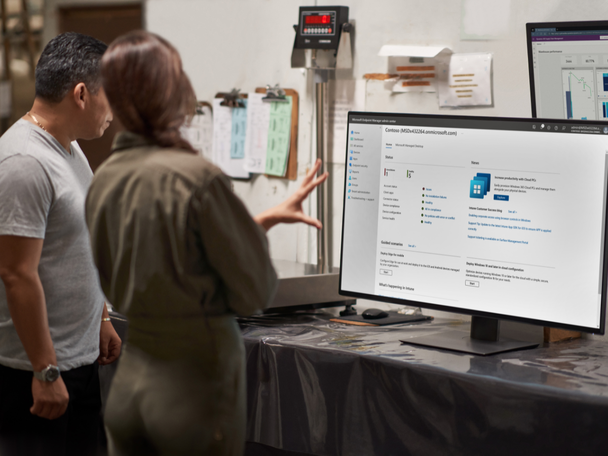 Two people looking at a computer monitor of Microsoft Endpoint Manager