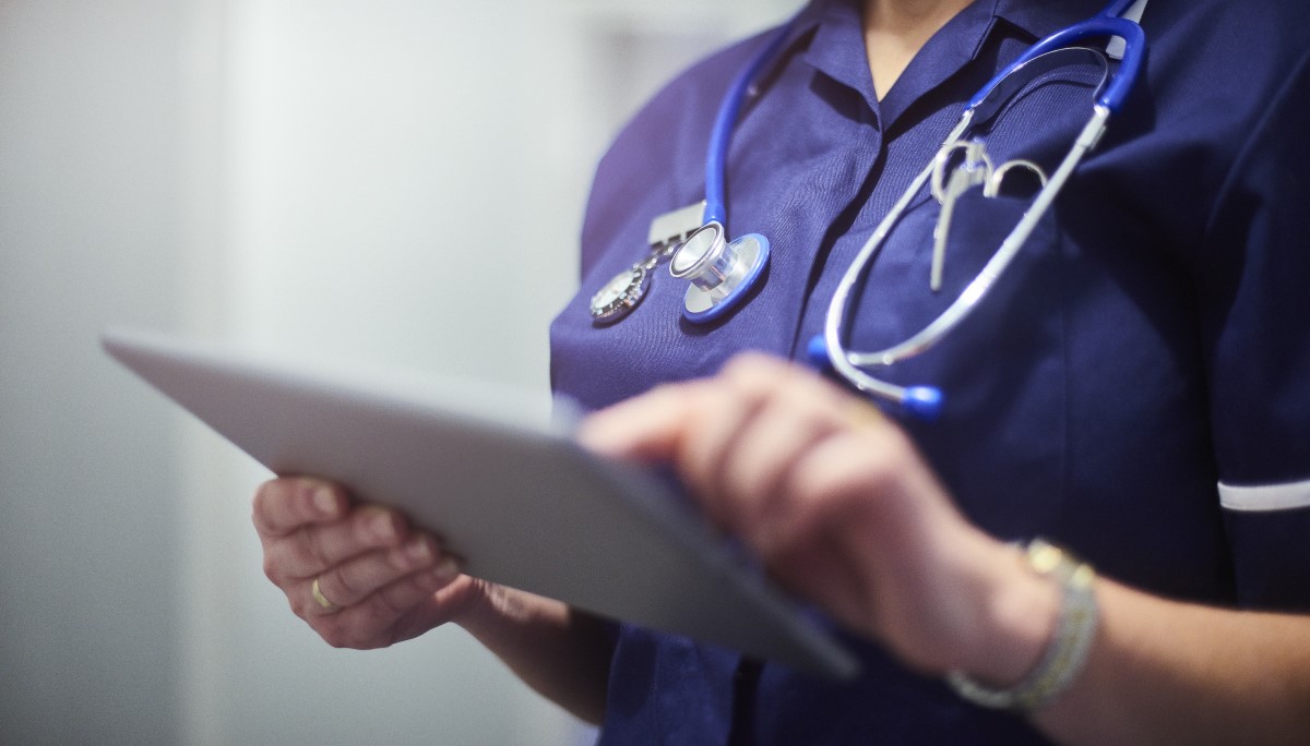 Female surgeon typing on digital tablet in hospital or surgery