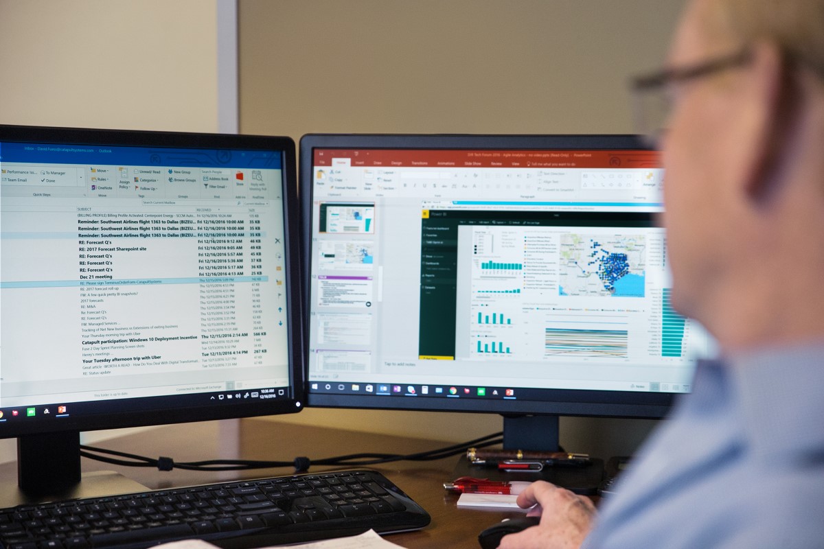 A man wearing glasses sorts through emails using Microsoft Outlook