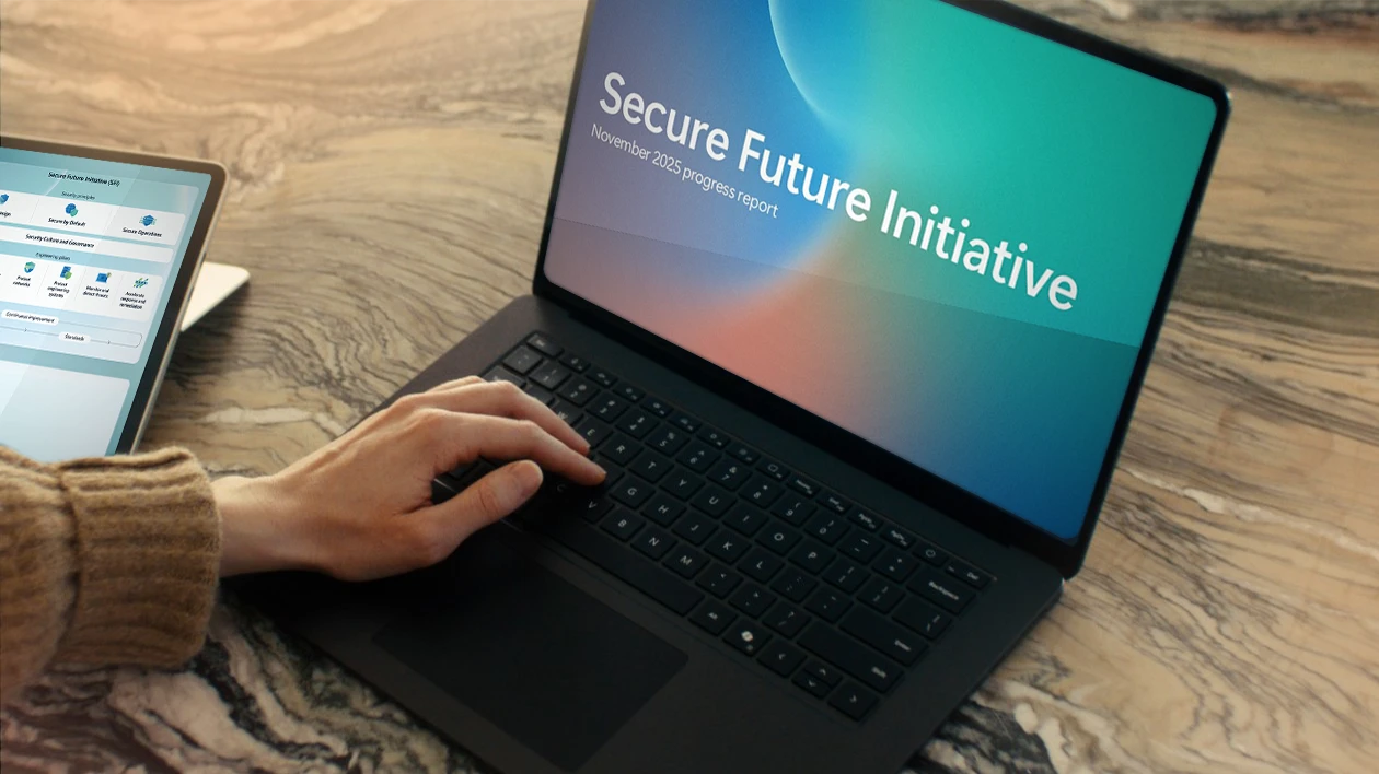Person typing on laptop with SFI report cover on laptop screen, with tablet on lefthand side of the desk with blue SFI graph on screen