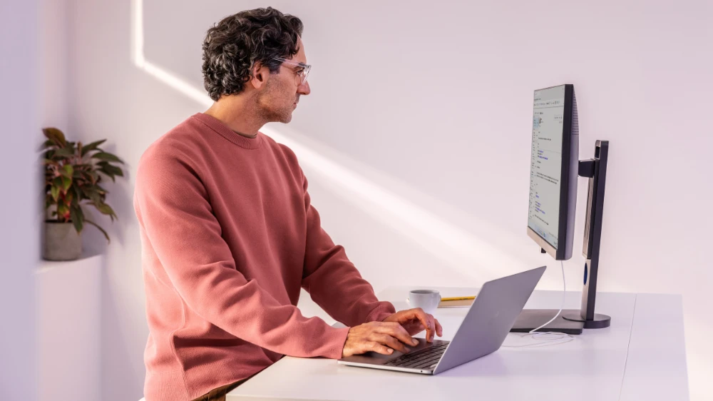 Man in focused work; able to do secure banking on a laptop at home or at the office