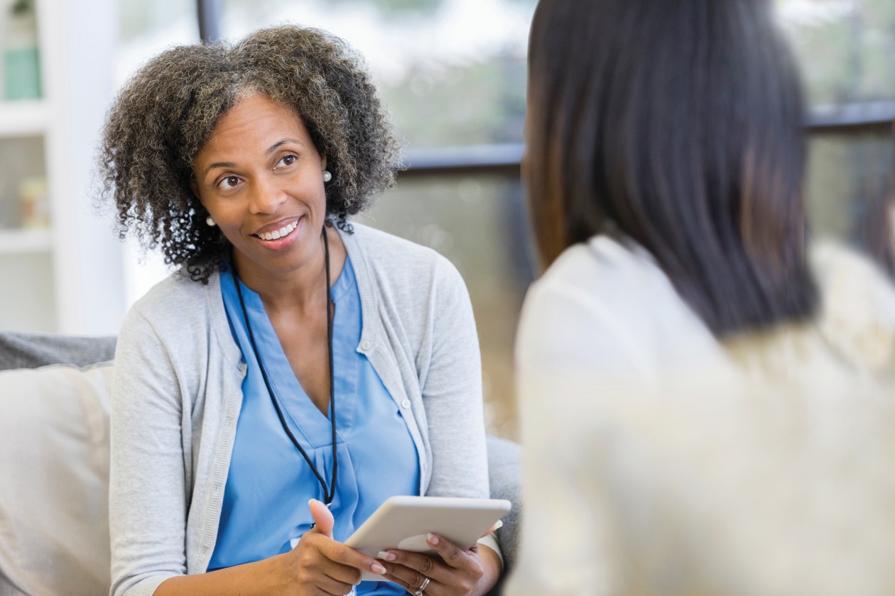 Female doctor talking with patient holding tablet