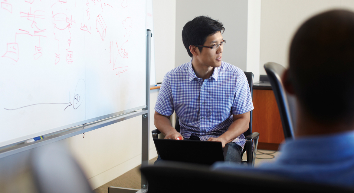 a man standing in front of a laptop