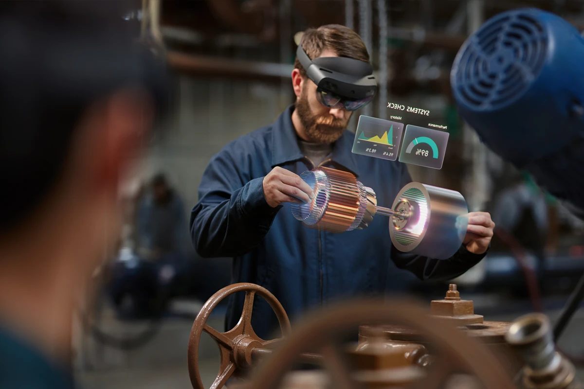HoloLens を装着して工場生産ラインで部品の性能をバーチャル確認する男性