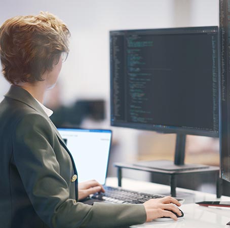 Um homem e uma mulher sentados observam um monitor durante uma apresentação.